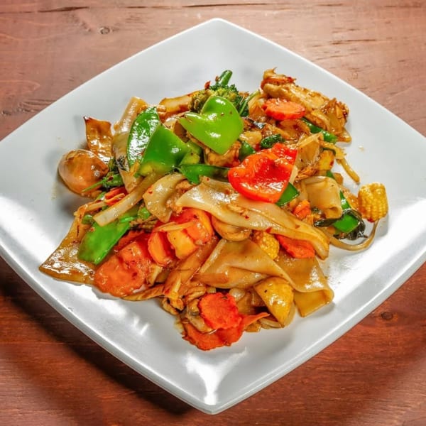Mai Thai Noodles & Sushi's Pad See Ew with wide noodles, chicken, and colorful vegetables.